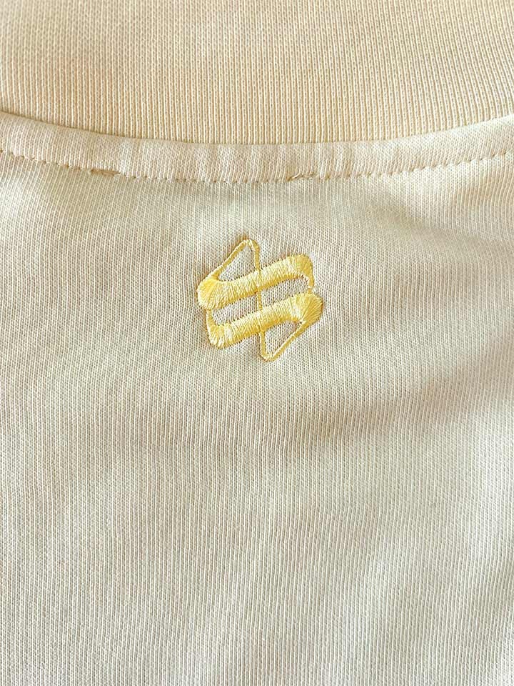 Yellow logo embroidery on beige fabric