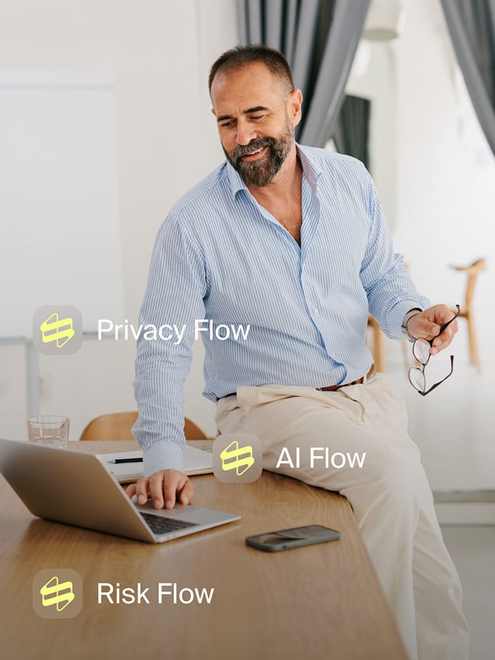 Man at his laptop with the privacy, AI and risk flows