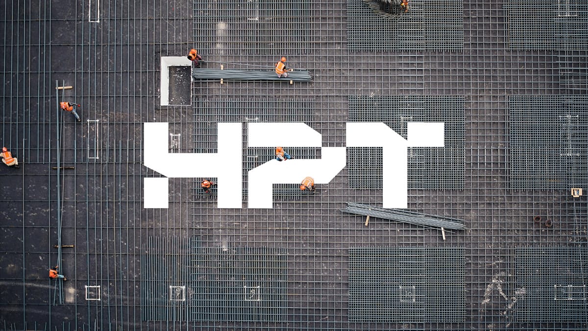 HPT key visual: the white angular HPT wordmark over an aerial photo of electricians laying cables on a construction site grid