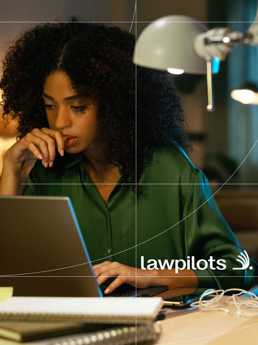 Woman working thoughtfully on her laptop in the evening