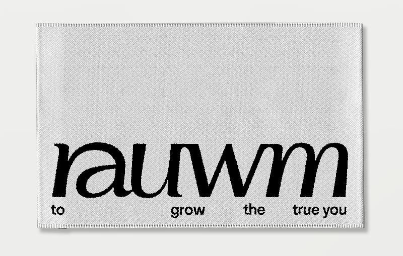 Woven fabric label with the black rauwm wordmark and the words “to grow the true you”