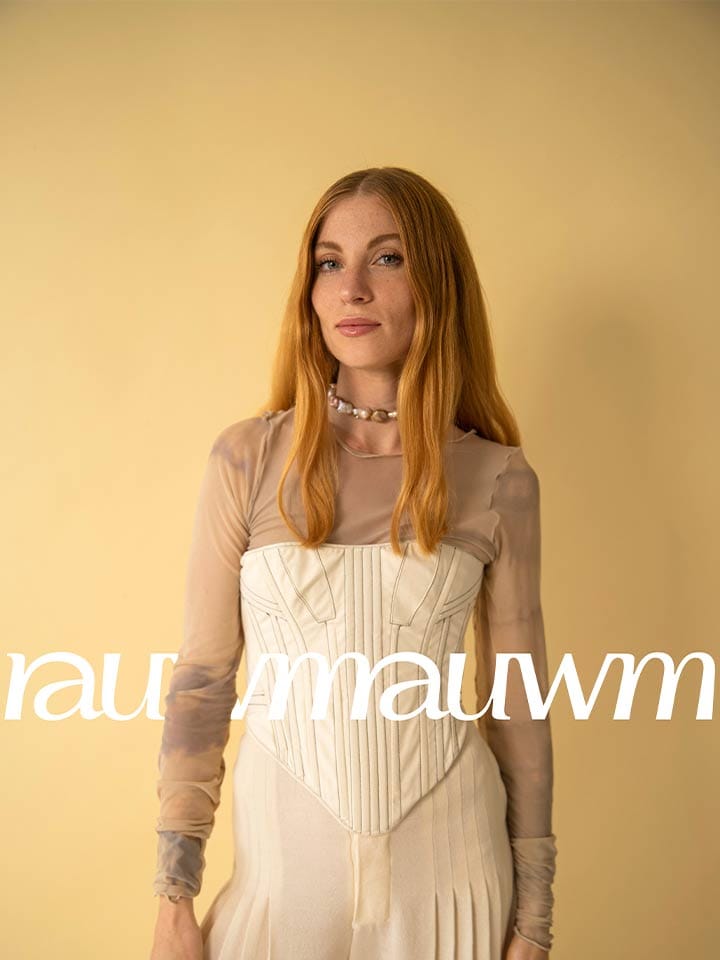 A woman in a cream corset in front of a yellow backdrop, the rauwm wordmark repeats across her hips