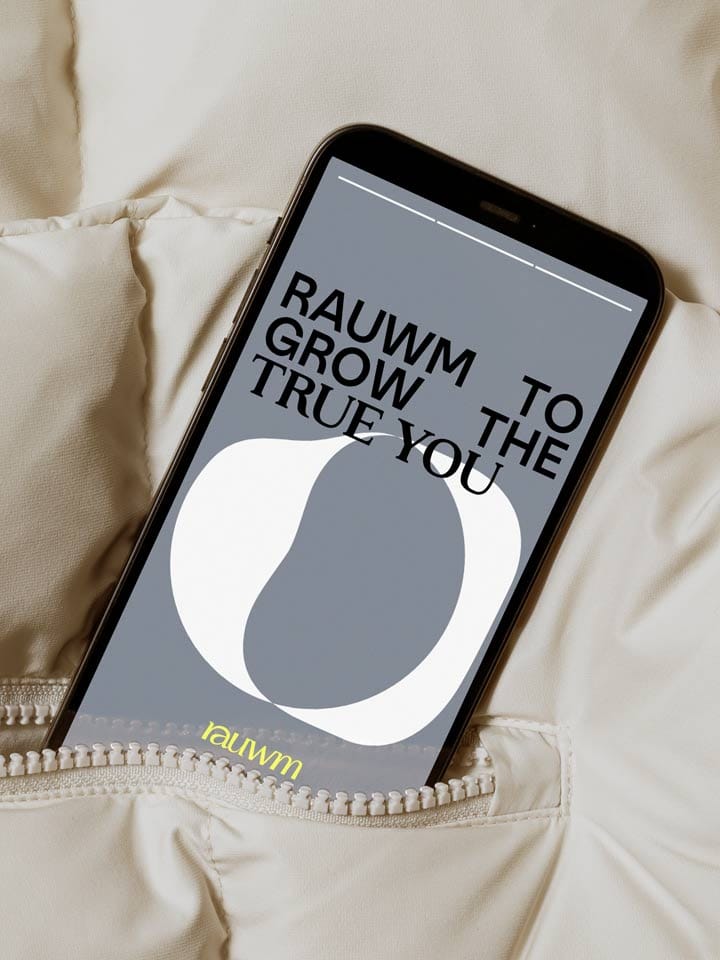 A phone in a cream down jacket pocket shows the claim “Rauwm to grow the true you” in black over the signet