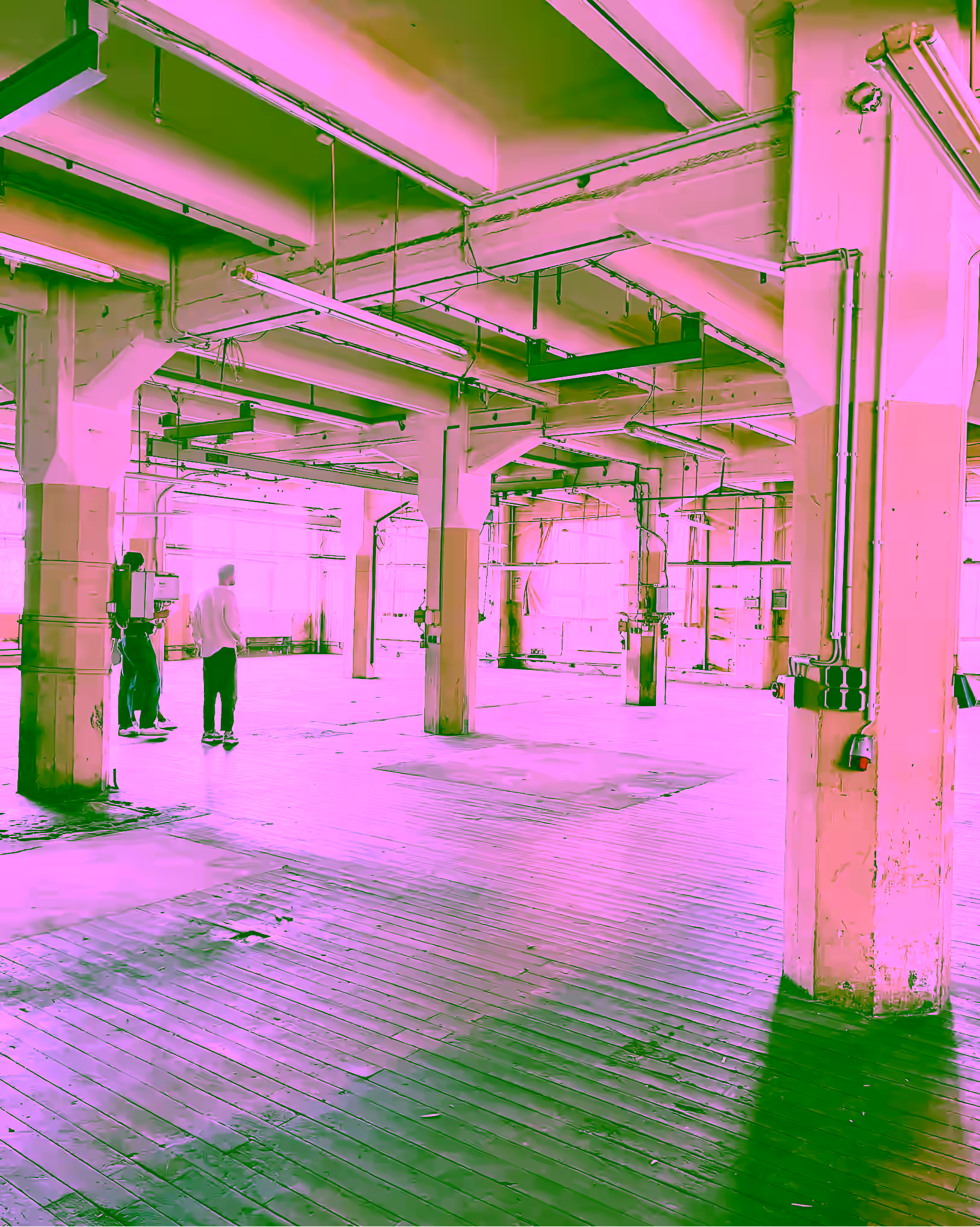 Empty industrial hall of the former factory with wooden floor and concrete pillars