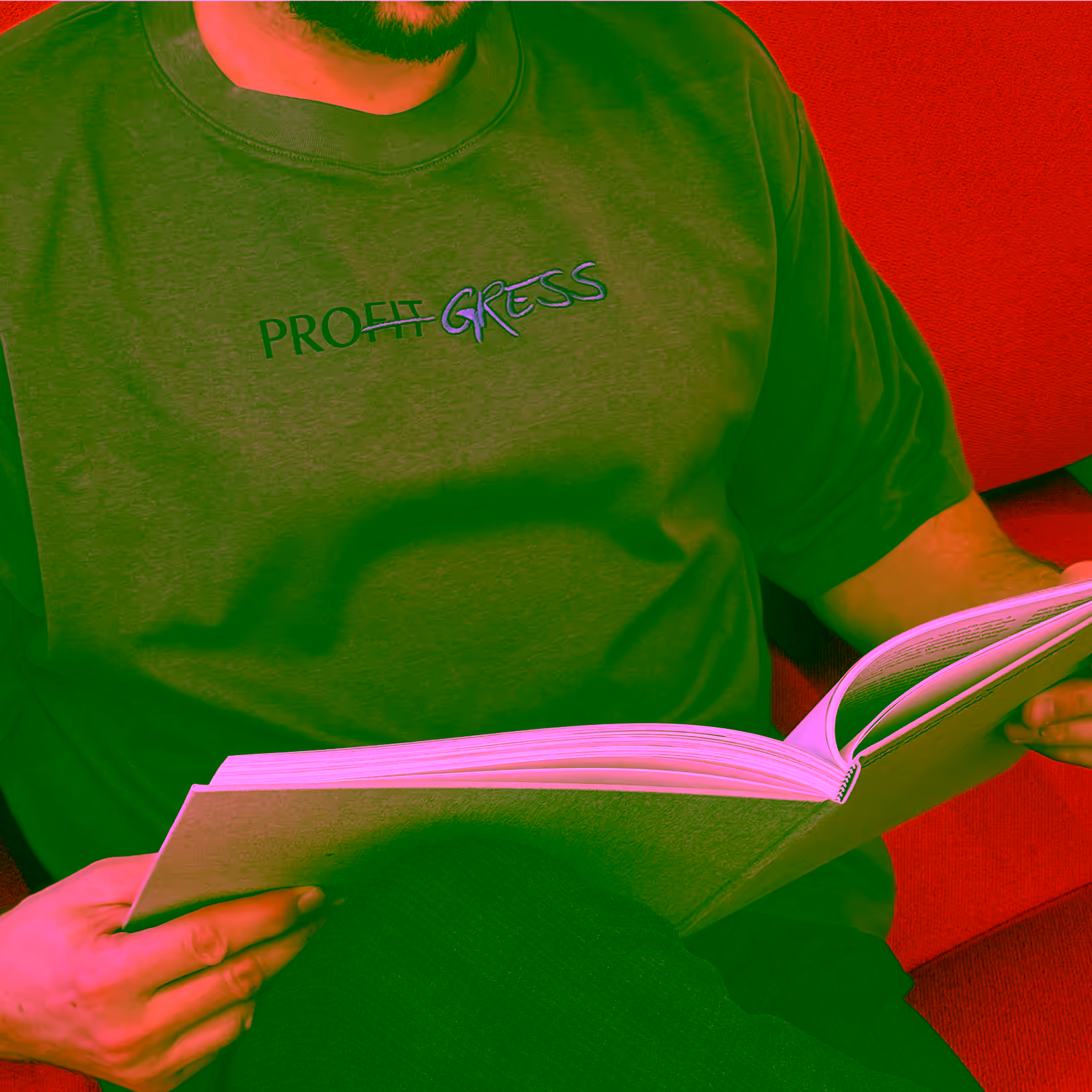 A person in a grey VERITAS shirt reading a book on an orange sofa