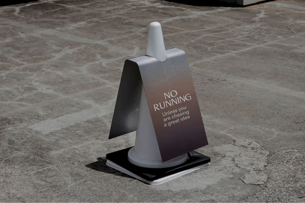 A metal VERITAS sign “No running” on a stone floor