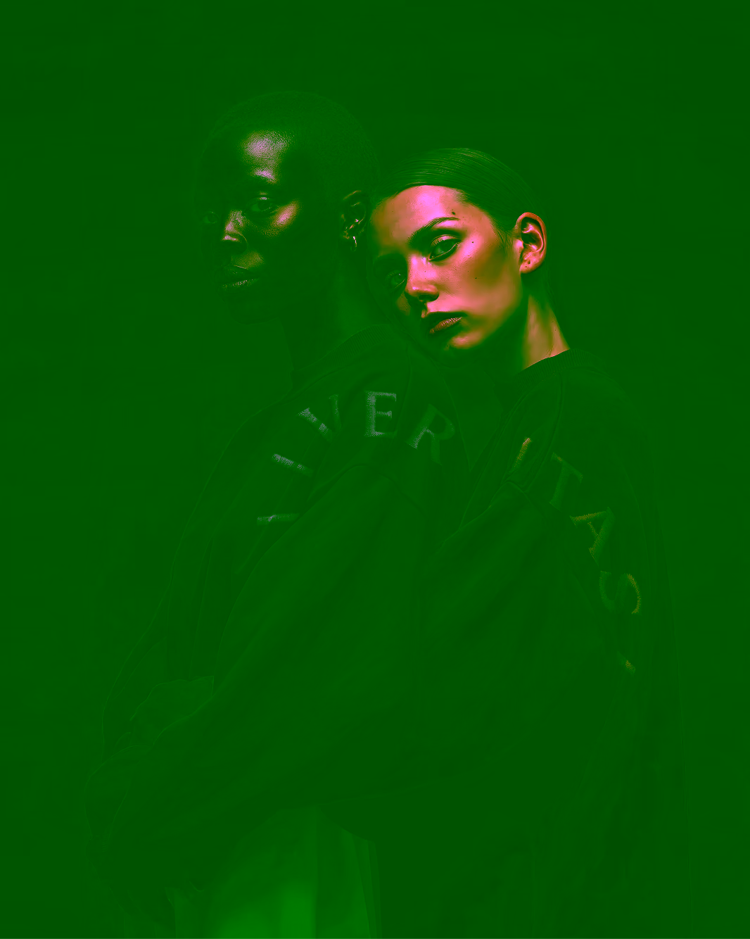 Two people in dark VERITAS sweatshirts leaning against each other